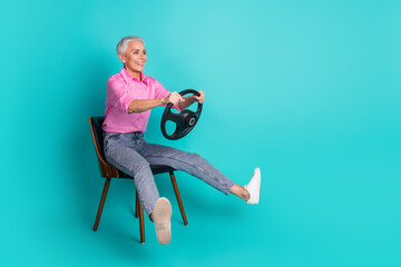 Poster - Photo of nice aged woman hold wheel empty space wear pink shirt isolated on teal color background