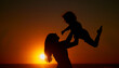 © Lumeez23/peopleimages.com - Mom, kid and happy with lifting at beach for bonding on break, relax and fun in Spain. People, family and playful on silhouette at ocean on holiday with smile for child development, growth and care