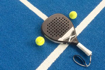 Wall Mural - padel racket on a padel blue court with a ball