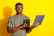© deagreez - Photo of nice handsome man wear stylish khaki clothes hold netbook isolated on yellow color background