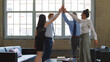 © Monkey Business - Multi-Cultural Business Team Celebrating Giving Each Other High Five In Modern Office