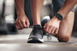 © Van Wyk/peopleimages.com - Hands, person and tie shoes at gym for exercise preparation, start workout and training sneakers of cardio. Athlete, fitness and ready feet for running activity, wellness goals and sports performance