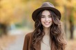 © ArtCookStudio - Young woman smiling in a brown hat during autumn in a wooded area