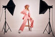 © FremtonClay/peopleimages.com - Woman, fashion and portrait in studio with lights, confidence and style for photography. Female person, hat and designer clothing on white background with softbox, videography or ready for production