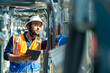 © CandyRetriever  - Professional Asian man engineer in safety uniform working on digital tablet at outdoor construction site rooftop. Industrial technician worker maintenance checking building exterior air HVAC systems.
