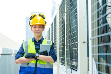 Wall Mural - Portrait of Professional Asian woman engineer in safety uniform working at outdoor construction site rooftop. Industrial technician worker maintenance checking building exterior air HVAC systems.