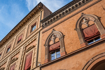 Detail of facade of Palazzo Isolani with mullioned windows with peaked arches and busts, Bologna ITALY 