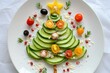 © Olena - Children snack, kids food. Serving dishes for New Year and Christmas. Creative Christmas tree made of cucumber, cherry tomatoes sprinkled with Parmesan cheese. Healthy food for breakfast. top view.