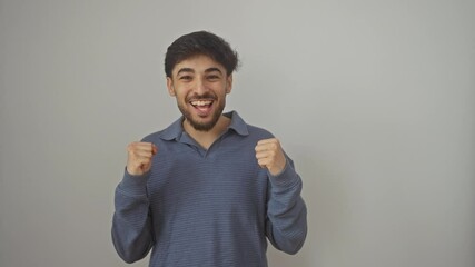 Poster - Young, victorious arab man standing ecstatic with arms raised, expressing pride and victory through his joyful screaming over an isolated white background