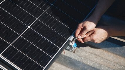 Wall Mural - Installation, Connection and mounting of solar panels. Two workers fasten solar panels. Technicians installing solar panels on metal stand. Workers installing PV solar panels on the roof of a house.