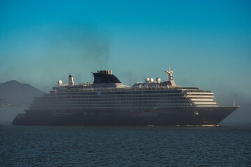 Super deluxe luxury cruiseship cruise ship ocean liner yacht Explora arrival in to San Francisco port with Golden Gate and misty foggy cloud bank over water