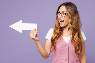 Wall Mural - Young surprised shocked successful employee business woman corporate lawyer wears classic suit vest white t-shirt glasses work in office showing aside with arrow isolated on plain purple background.