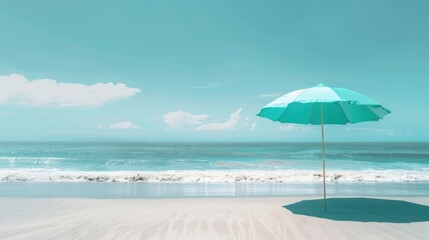 A turquoise umbrella providing shade on a sunny beach, with waves in the background