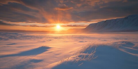 Wall Mural - Sunset over snow-covered mountains with a glowing sky.