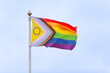 © Nicky - Progress Pride flag on flag pole in front of blank sky