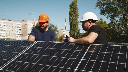 Wall Mural - Connection and installation of solar panels. Workers attach solar panels. Technicians install solar panels on a metal stand. Workers install photovoltaic solar panels on the roof of a house.