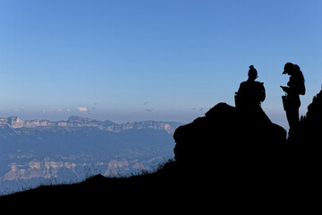 Wall Mural - Silhouettes of hikers on the slopes of Belledonne mountain range in french alps