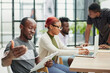 © Katsiaryna - team of employees in a modern office at work. young african american man looking at camera