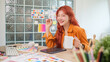 © wattana - Cheerful young graphic designer with red hair holding a coffee mug working at creative office.