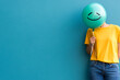 © Pompozzi - Person Holding Smiley Balloon Against Blue Background