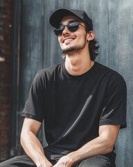 Sticker - A young attractive man sitting with wearing a blank black mockup t-shirt