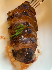 sliced ​​fried meat fillet in spices. Steak. Served medium rare and sliced thinly plated on white plate. Classic American restaurant favorite. 