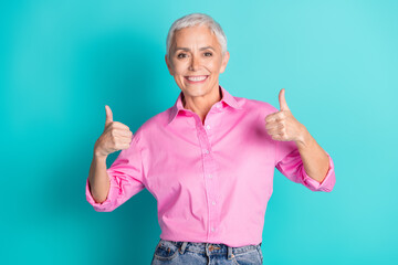 Poster - Photo of nice aged woman show thumb up wear pink shirt isolated on teal color background