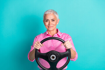 Wall Mural - Photo of nice aged woman steering wheel wear pink shirt isolated on teal color background