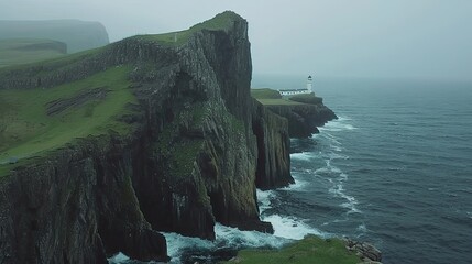 Wall Mural - A rocky cliff overlooks the ocean with a lighthouse in the distance