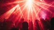 © Nathamanee - A crowd of people are at a concert, with the stage lit up in red