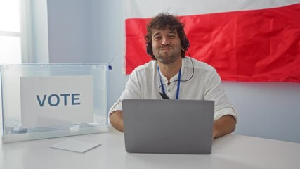 Sticker - Young hispanic man puffs cheeks funny face with inflated mouth and headphones at computer in polish electoral college