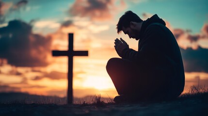 Wall Mural - Christian man praying in front of the cross at sunset