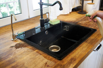 the process of cleaning a black kitchen sink