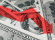 © shchus - The light red arrow icon on a background of money. The concept of changing course of US dollar on the market. Devaluation, collapse, stagnation of the economy.