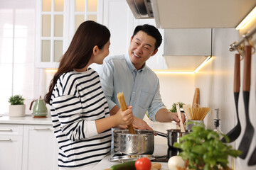 Poster - Happy lovely couple cooking together in kitchen