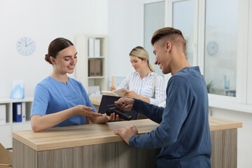 Sticker - Receptionist taking payment from client via terminal at hospital