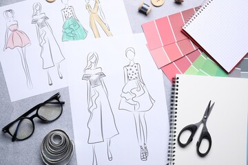 Poster - Sketches of stylish clothes and other fashion designer`s supplies on grey table, flat lay