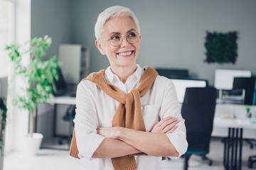 Wall Mural - Photo of nice boss mature woman crossed hands look interested empty space dressed formalwear comfortable light startup office room interior