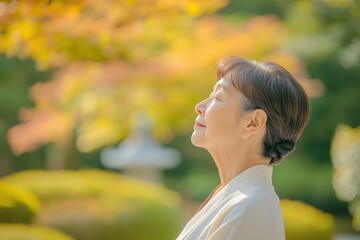 Wall Mural - Inner Peace: Older Asian Woman Practicing Mindful Breathing in Tranquil Garden Setting