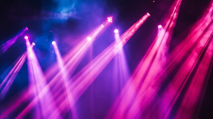 Poster - A stage covered in rich, colorful lights with a focus on the intense beams cutting through the darkness.