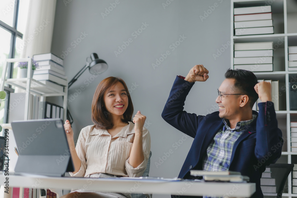 Young happy asian entrepreneurs raising their arms in the air ...
