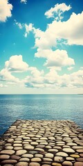 Poster - Cobblestone Pathway Leading to the Ocean Under a Blue Sky