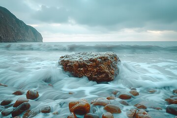 Wall Mural - A large rock is in the ocean, with the waves crashing around it