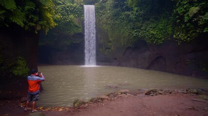 Wall Mural - Travel people enjoy beautiful view Bali waterfall Tibumana hidden in tropical rainforest jungle near Ubud, Bali, Indonesia 4K