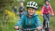 © florynstudio3 - A young boy wearing a helmet smiles while riding his bike, with other cyclists in the background.