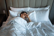 © kieferpix - Sleepless man lying in bed waking up tired yawning suffering from insomnia