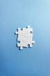 © ClareM - Four puzzle elements on a blue background. Vertical banner. Abstract concept for business and education. Copy space