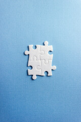 Four puzzle elements on a blue background. Vertical banner. Abstract concept for business and education. Copy space