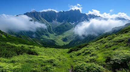 Majestic mountain range with rolling green hills and white clouds in the sky.