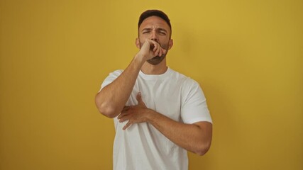 Poster - Coughing young hispanic man wearing white t-shirt standing unwell with cold and bronchitis over isolated yellow background for health care